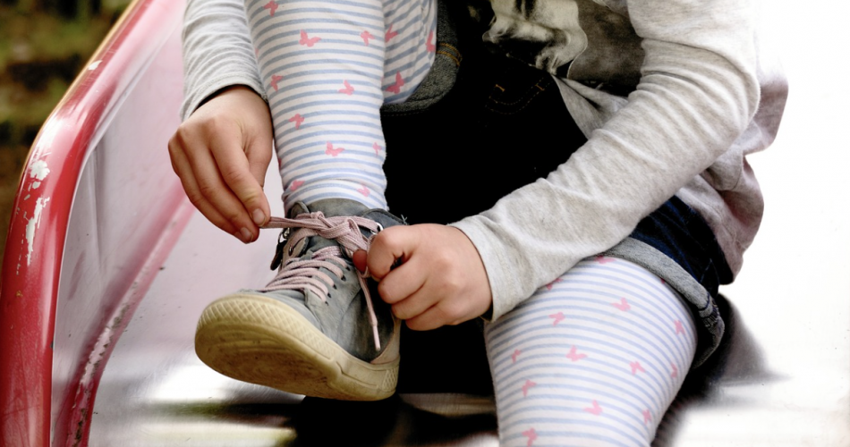 Kind beim Schuhe binden