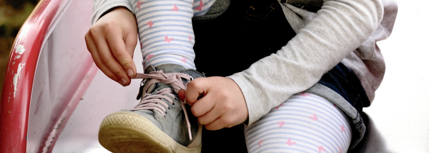 Kind beim Schuhe binden